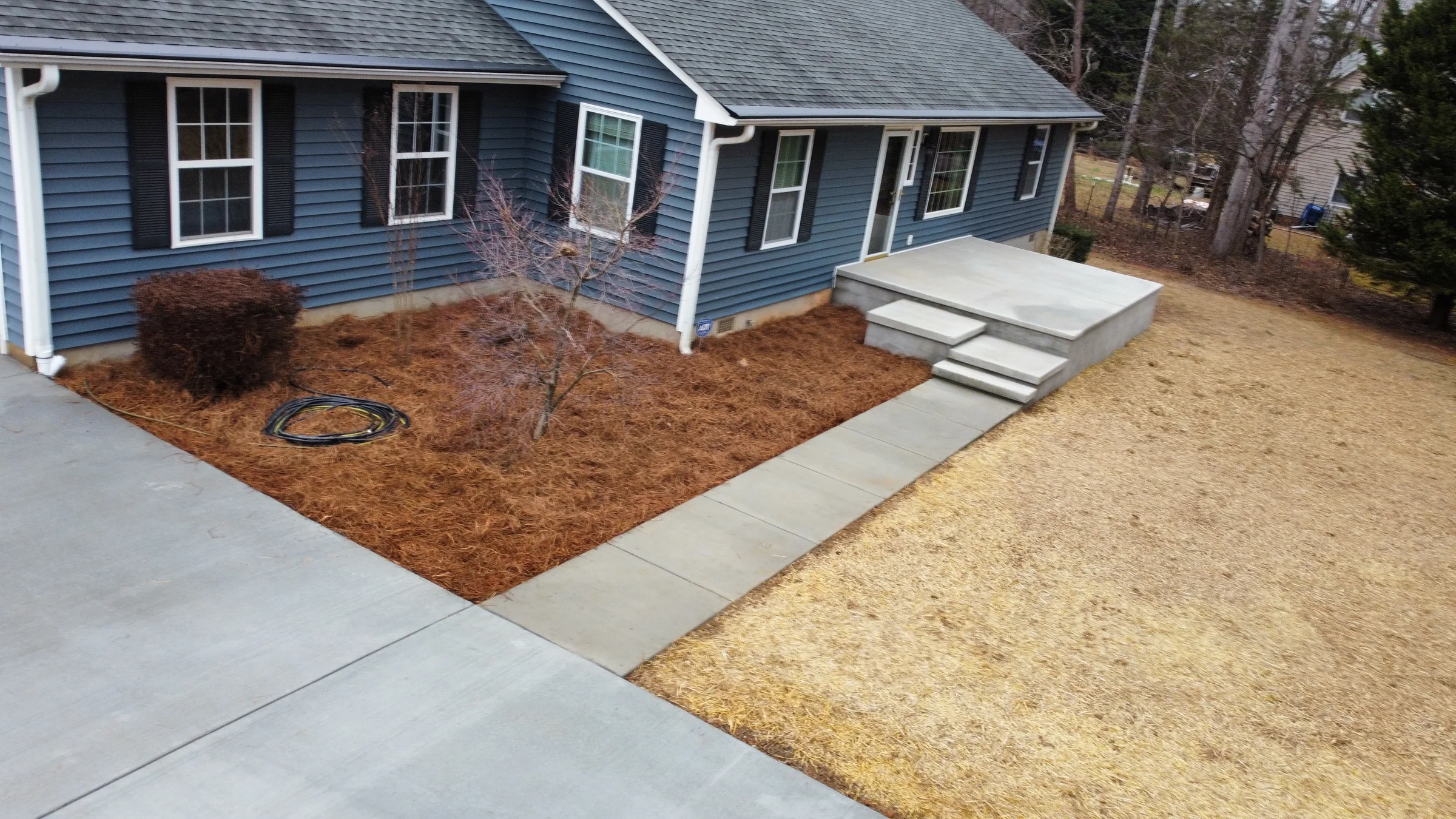 Finished concrete entry steps and walkways at a blue home